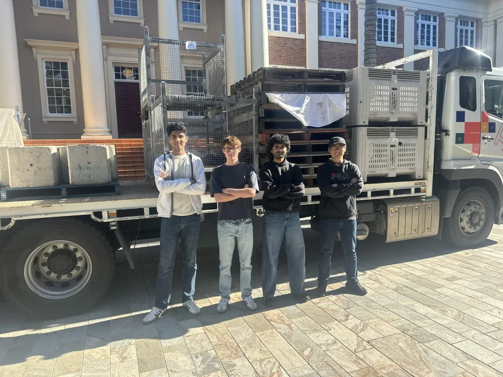 The four of us in front of a flatbed truck outside U Block at QUT